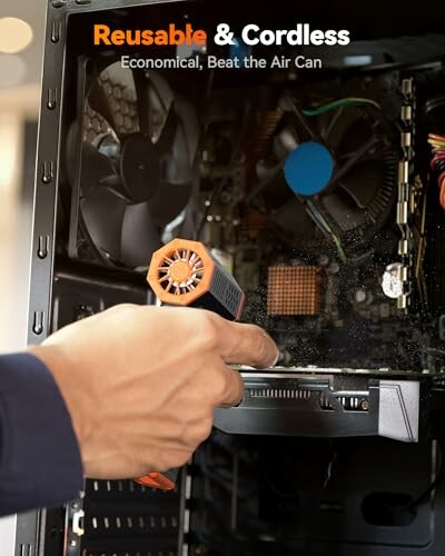 Hand using a cordless air blower to clean computer internals.